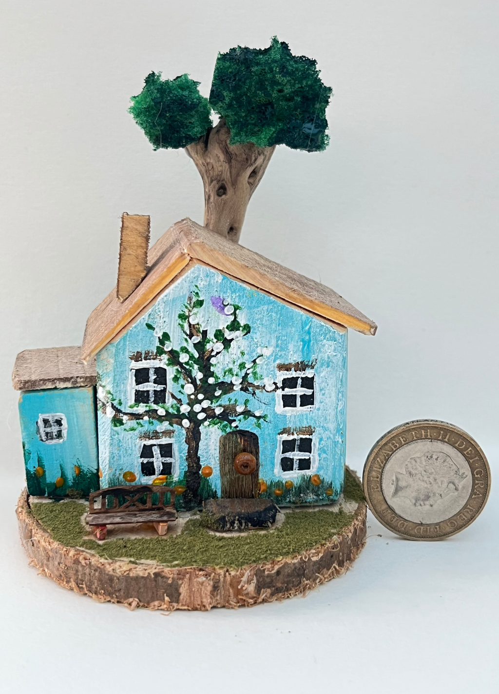 Miniature diorama with a house, and plants on a white background (RRH1042)