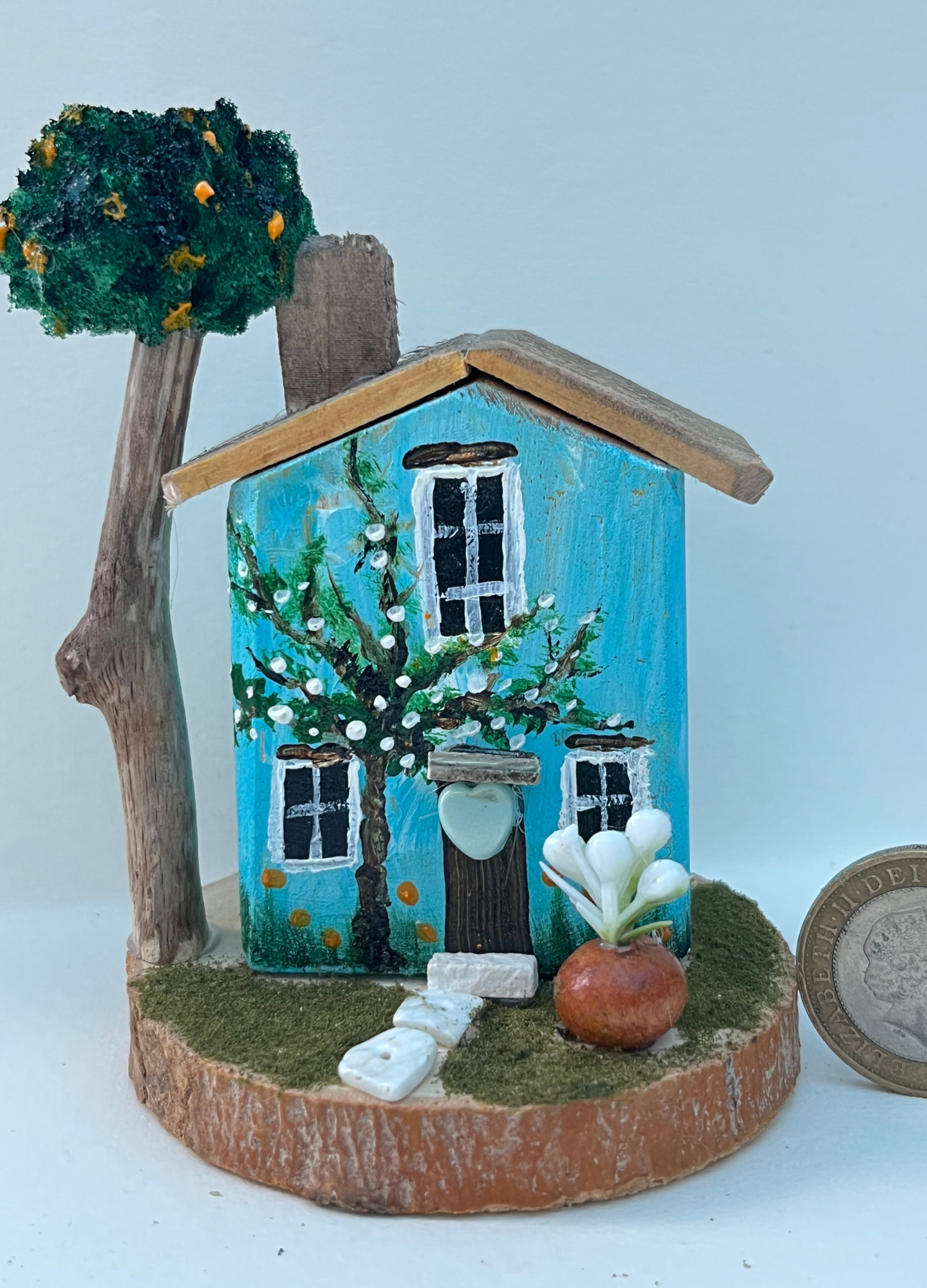 Miniature diorama with a house, and plants on a white background (RRH1046)