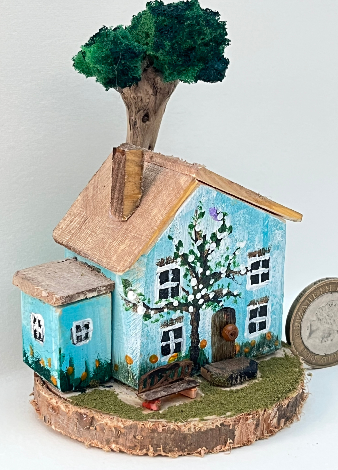 Miniature diorama with a house, and plants on a white background (RRH1042)