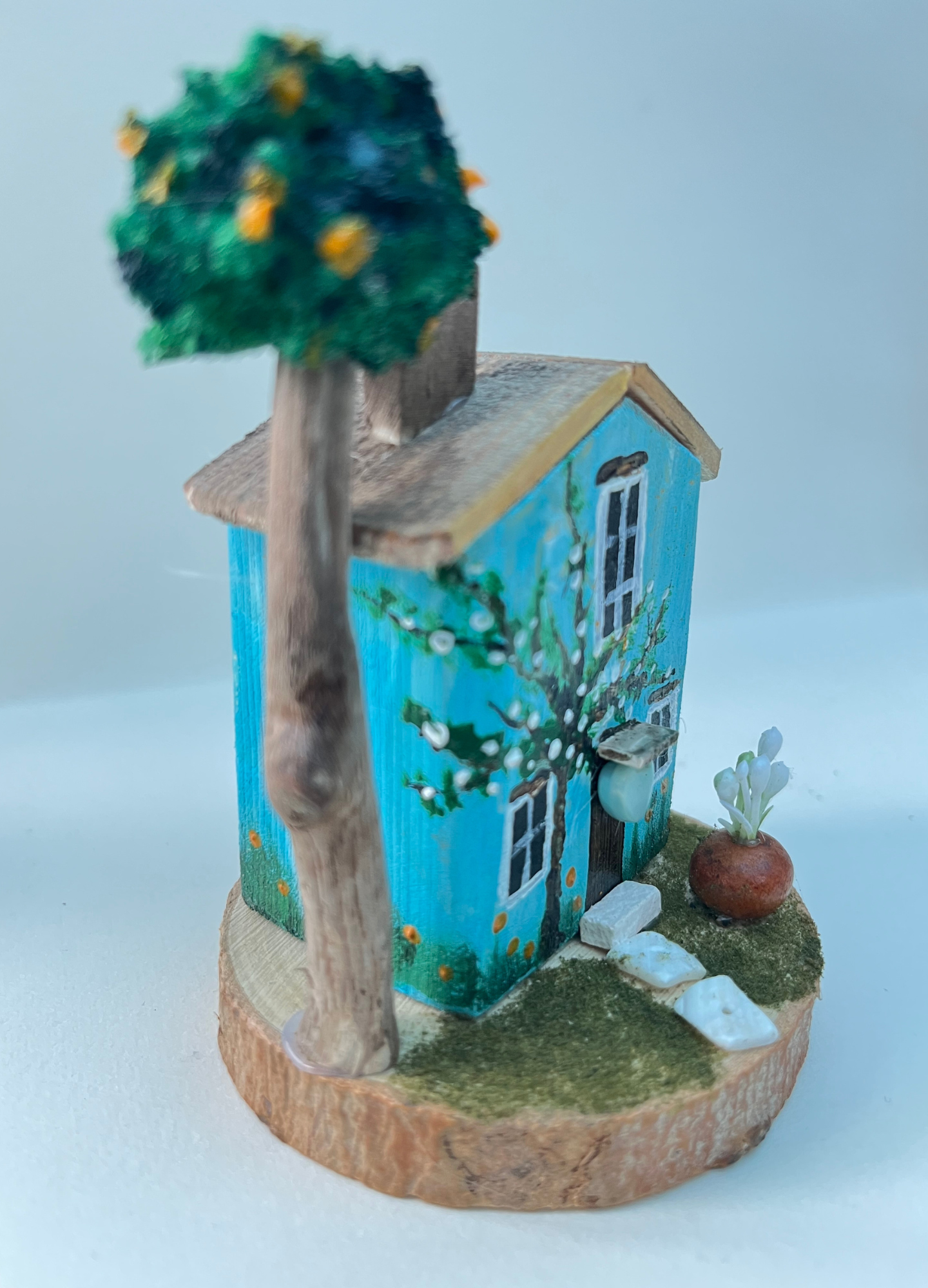 Miniature diorama with a house, and plants on a white background (RRH1046)