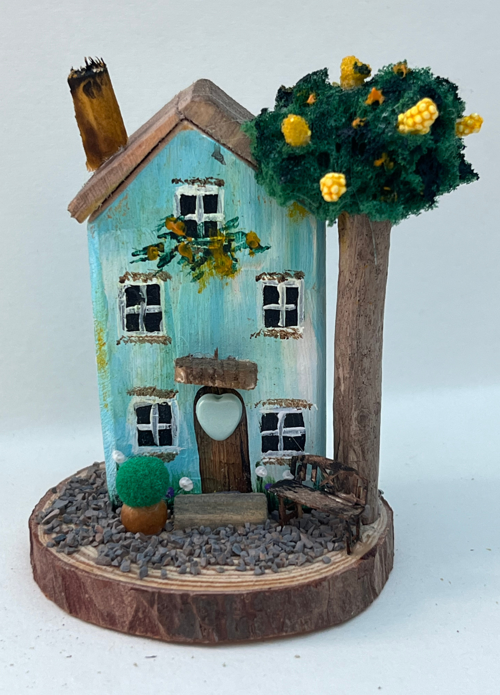 Miniature diorama with a house, and plants on a white background (RRH1047)