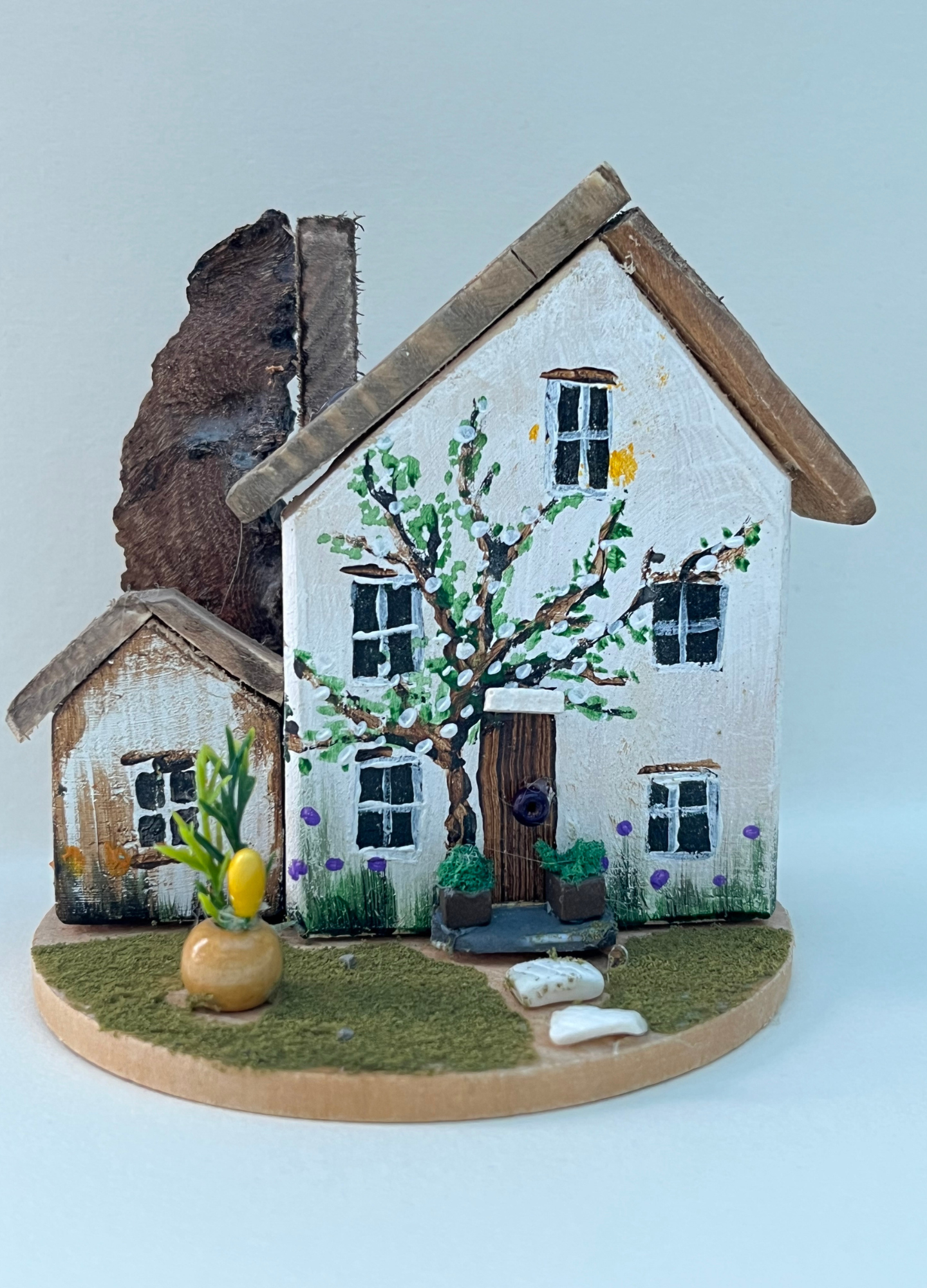 Miniature diorama with a house, and plants on a white background (RRH1043)