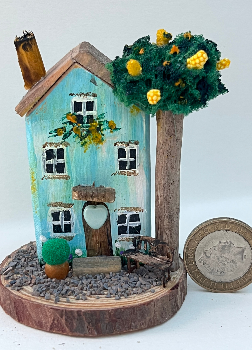 Miniature diorama with a house, and plants on a white background (RRH1047)