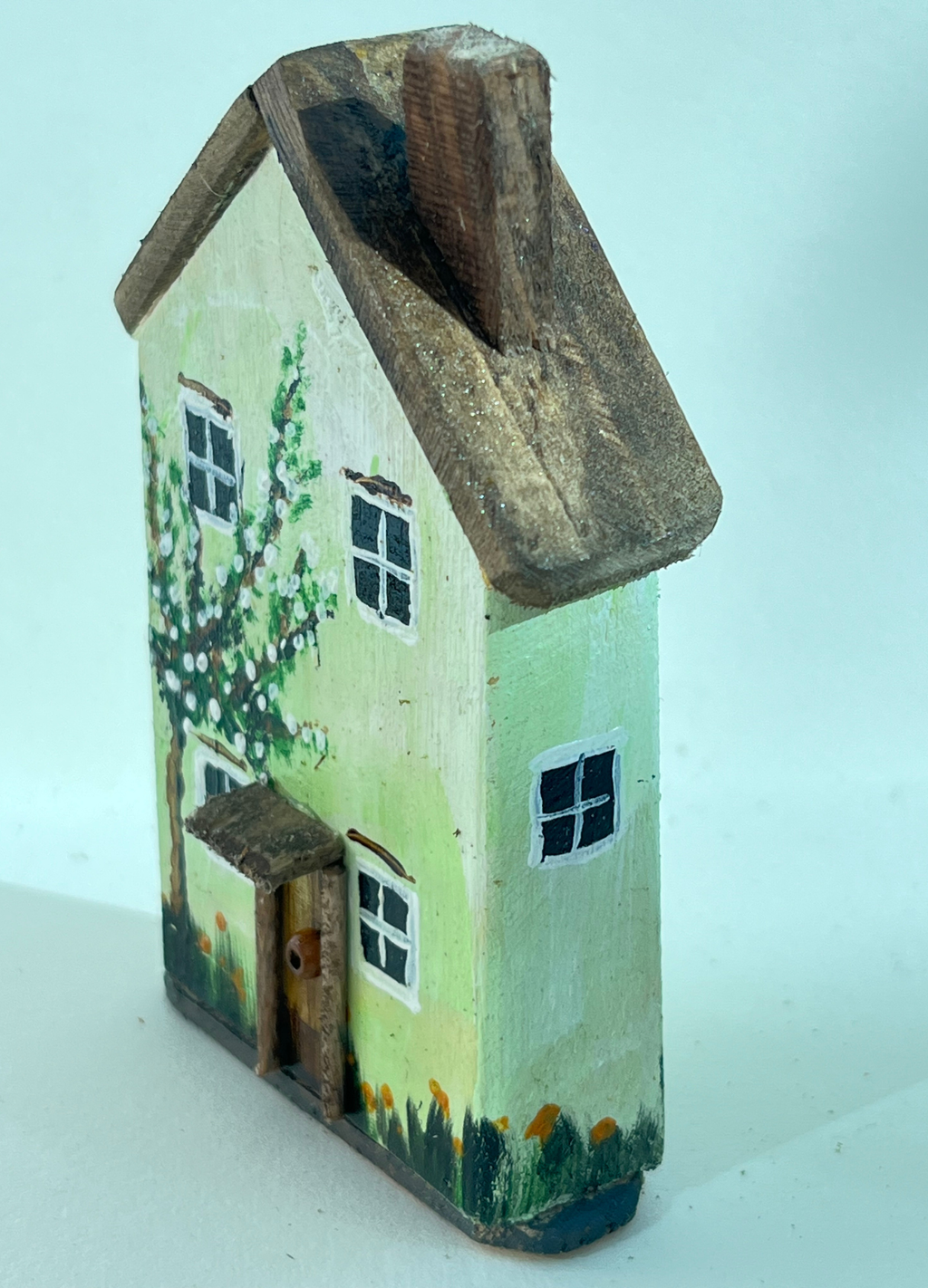 Miniature diorama with a house, and plants on a white background (RRH1049