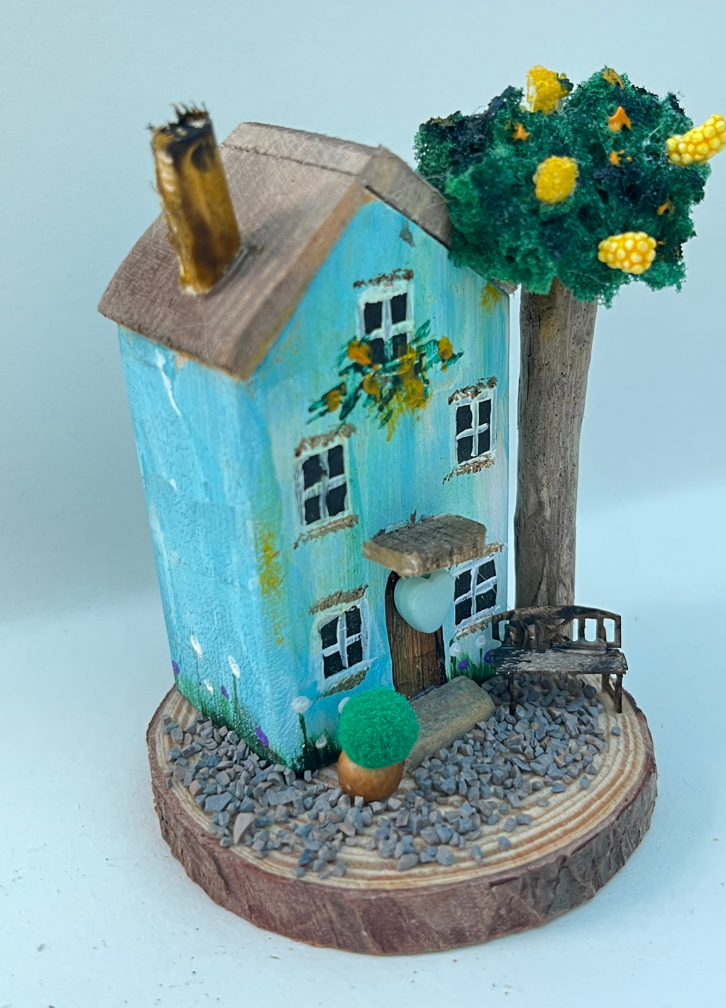 Miniature diorama with a house, and plants on a white background (RRH1047)