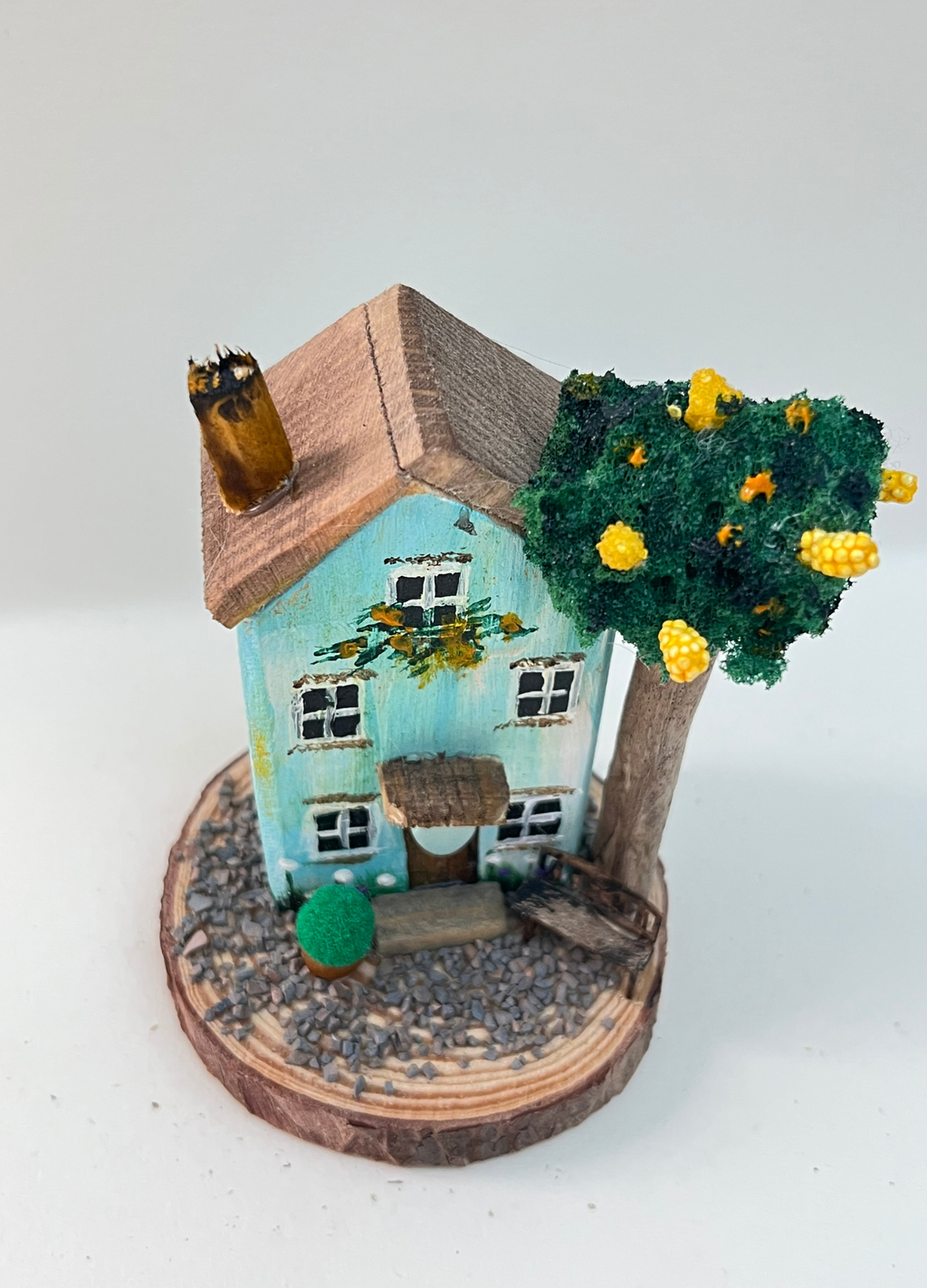 Miniature diorama with a house, and plants on a white background (RRH1047)