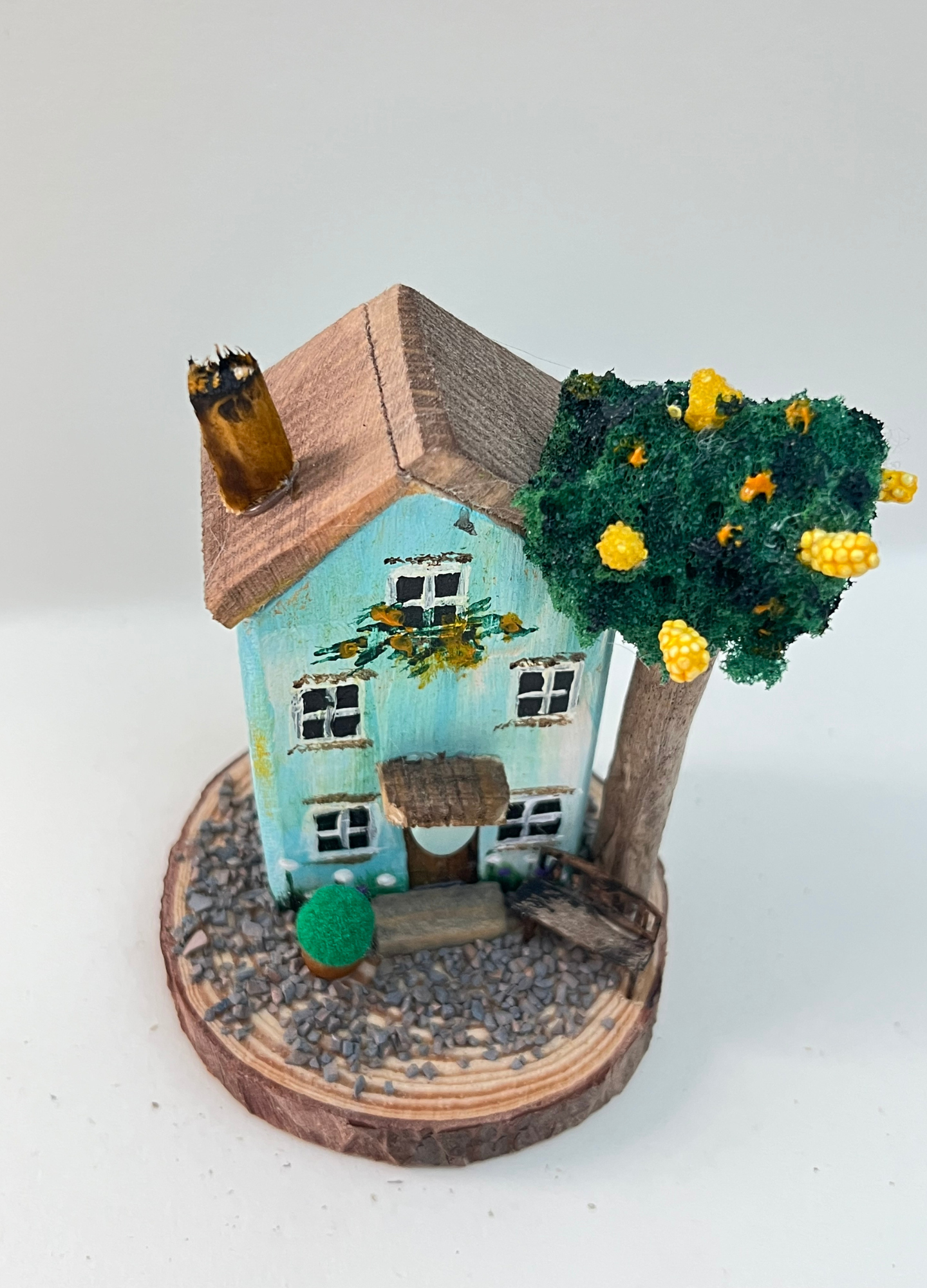 Miniature diorama with a house, and plants on a white background (RRH1047)