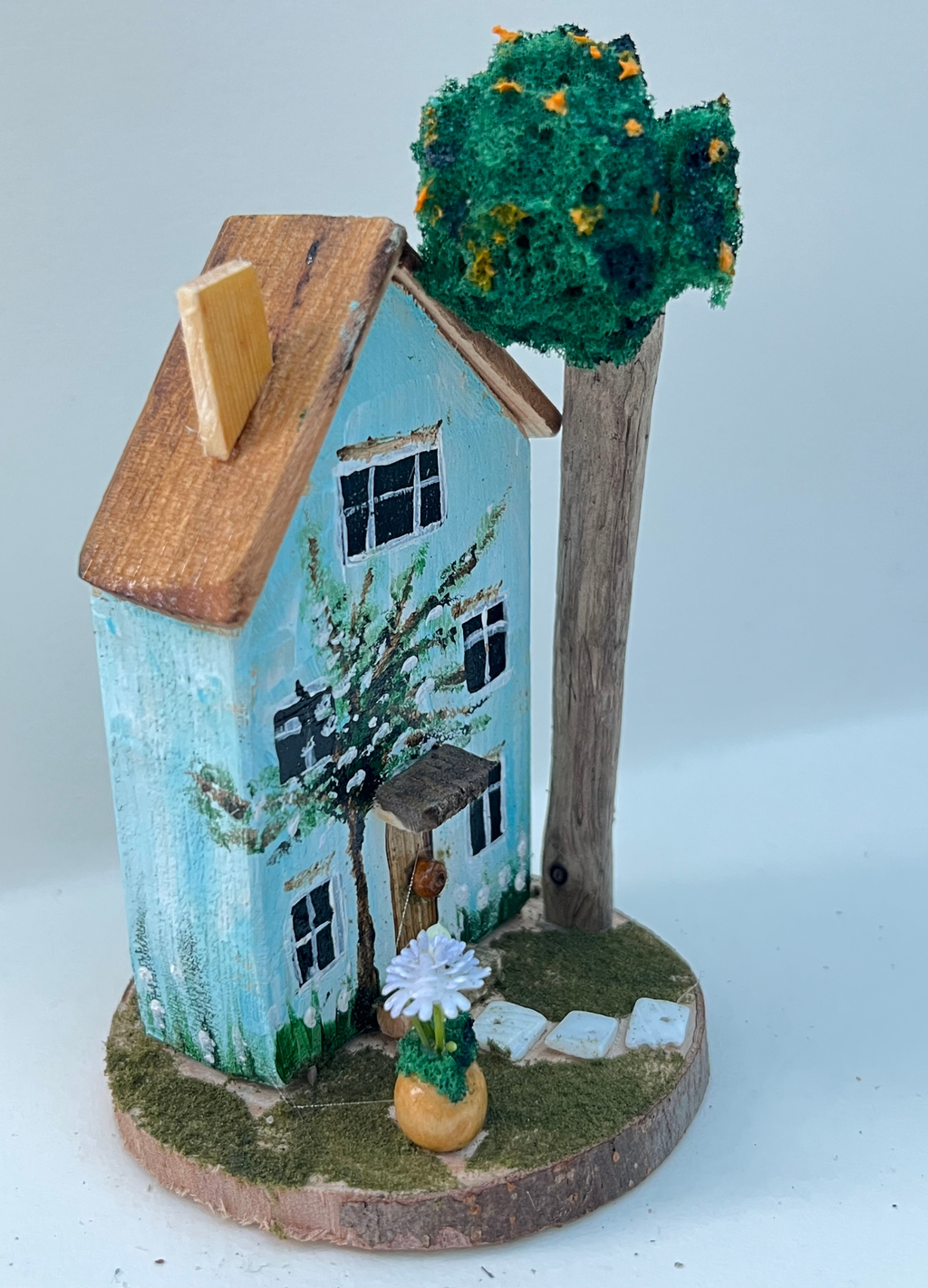 Miniature diorama with a house, and plants on a white background (RRH1048)