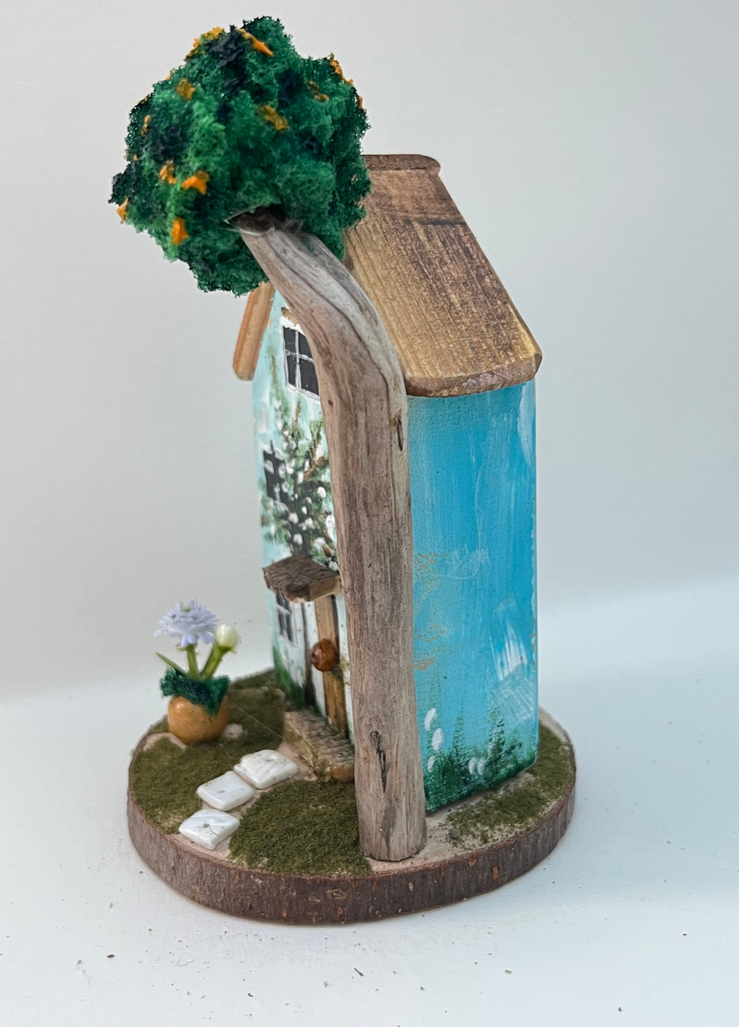 Miniature diorama with a house, and plants on a white background (RRH1048)