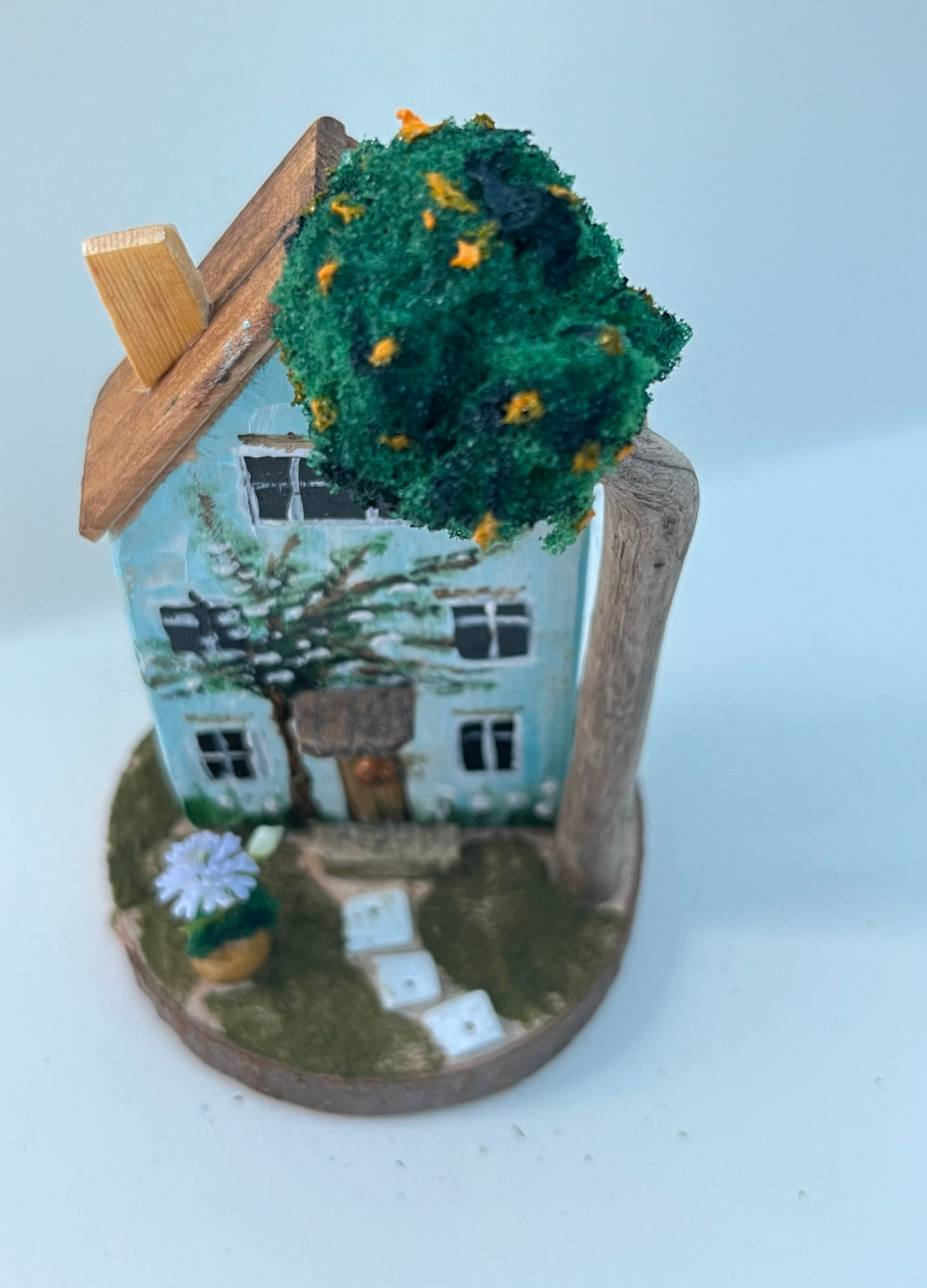 Miniature diorama with a house, and plants on a white background (RRH1048)