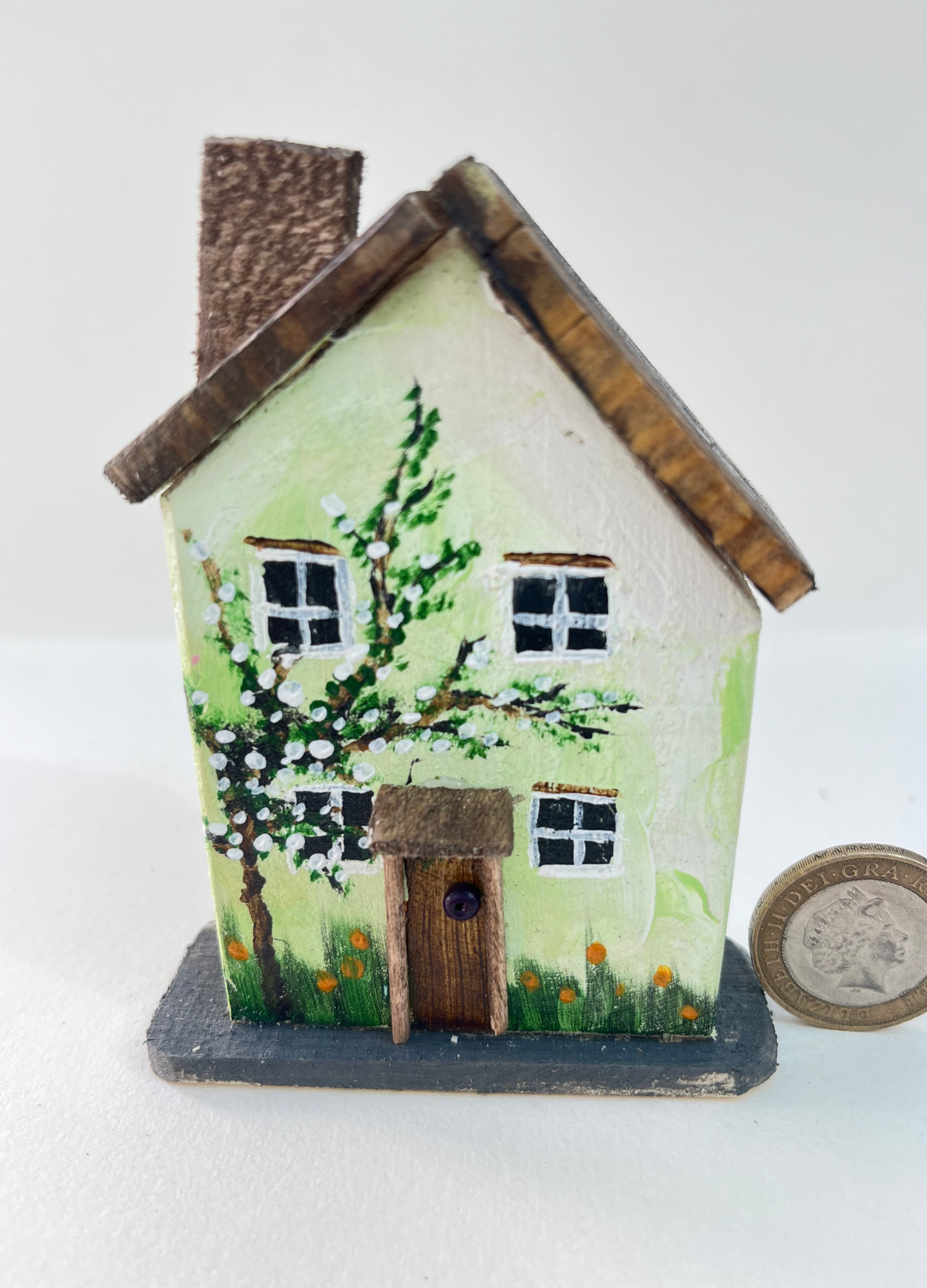 Miniature diorama with a house, and plants on a white background (RRH1049