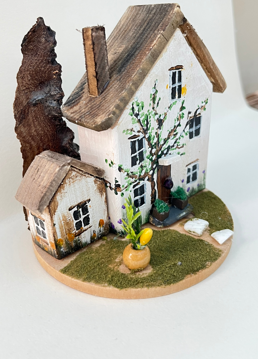 Miniature diorama with a house, and plants on a white background (RRH1043)