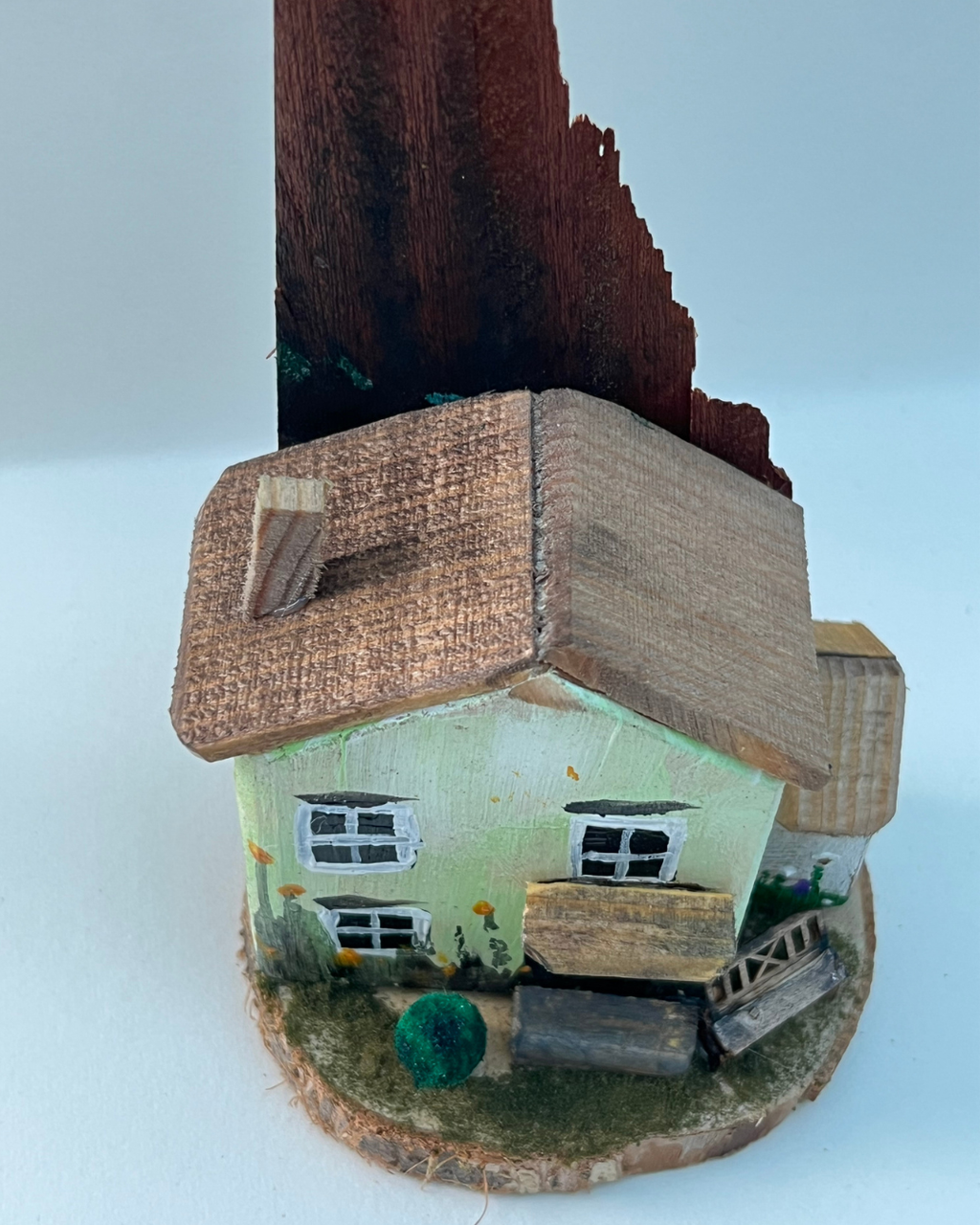 Miniature diorama with a house, bench, and plants on a white background (RRH1039)