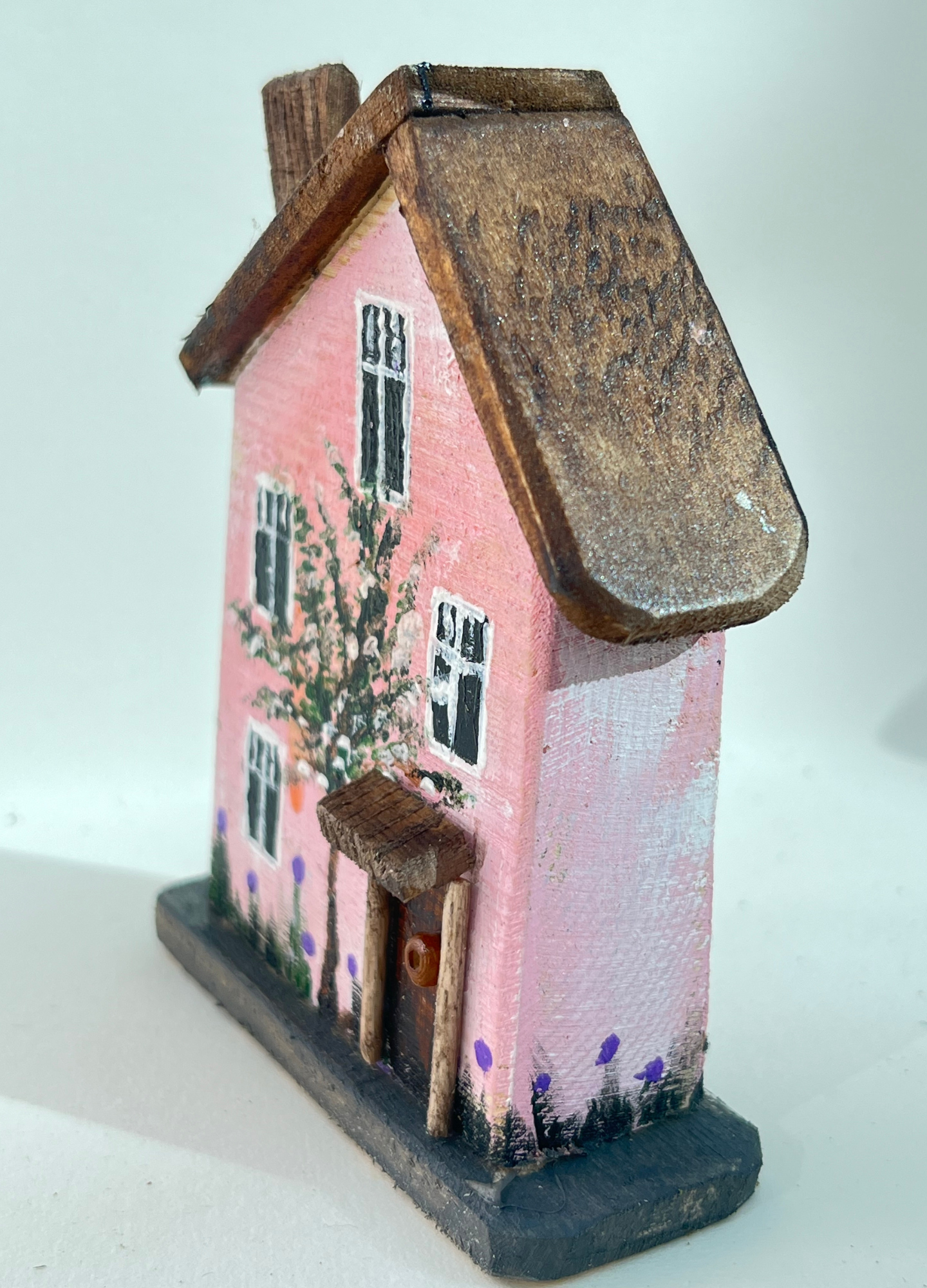 Miniature diorama with a house, and plants on a white background (RRH1052)