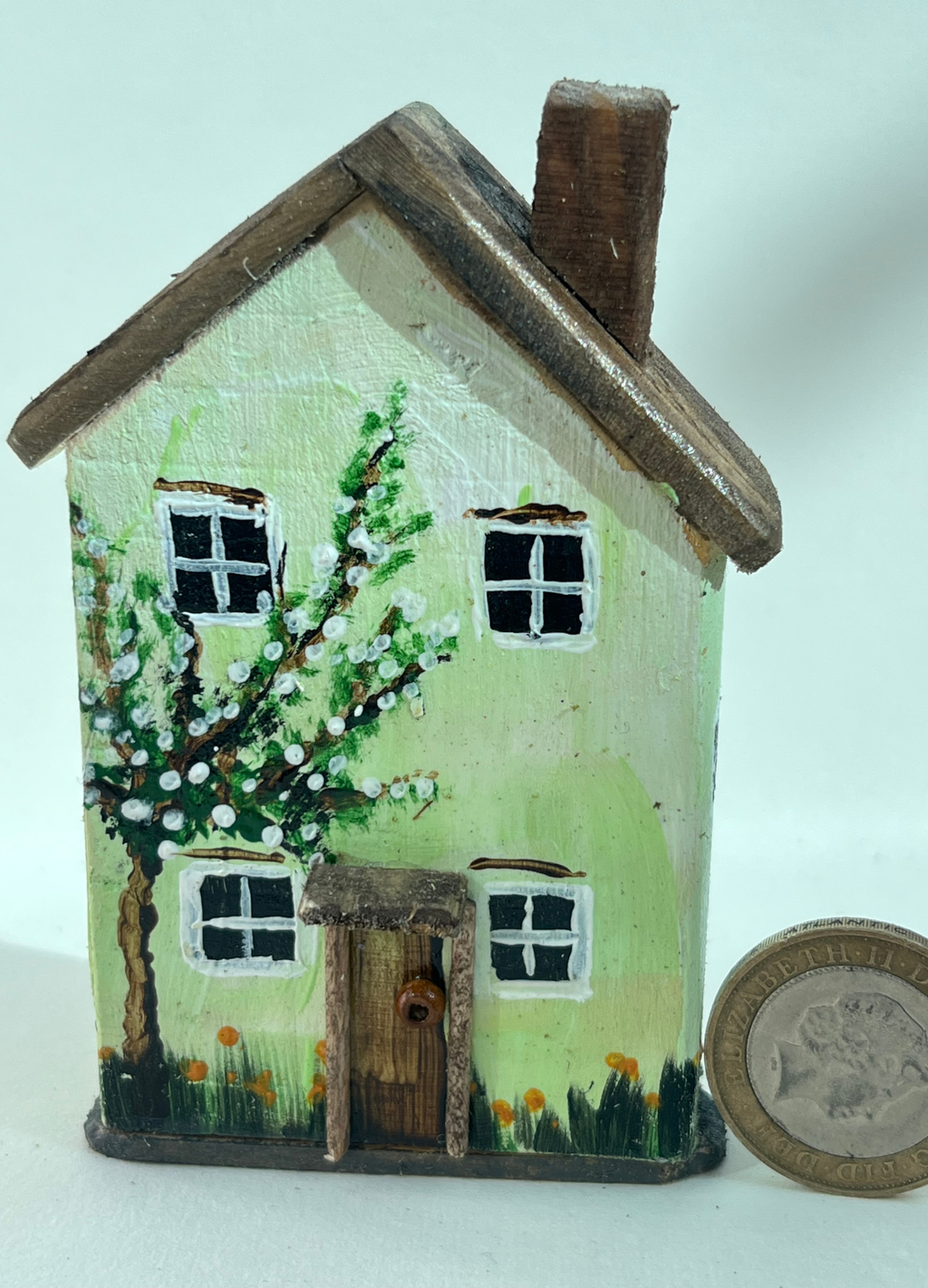 Miniature diorama with a house, and plants on a white background (RRH1055)
