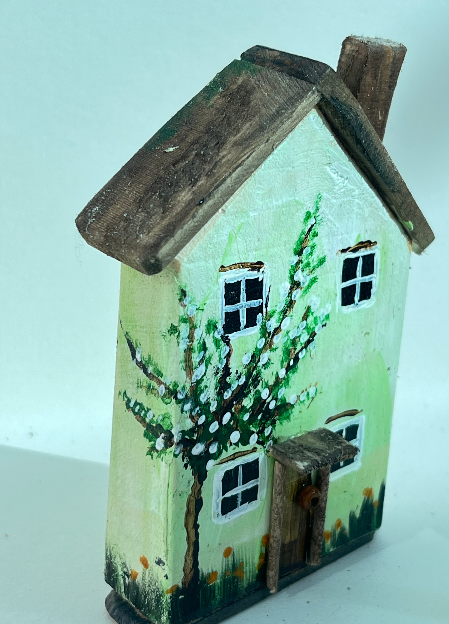 Miniature diorama with a house, and plants on a white background (RRH1055)