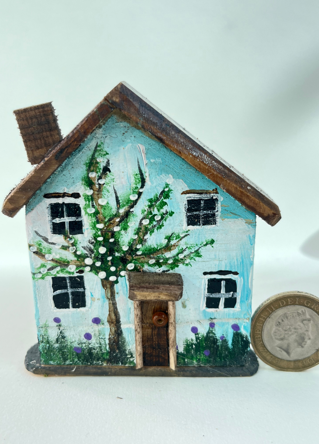 Miniature diorama with a house, and plants on a white background (RRH1054)