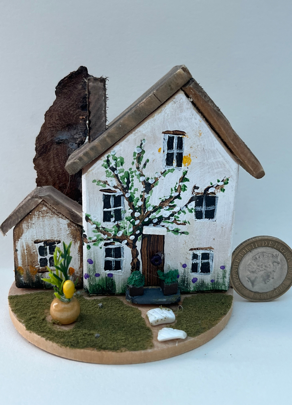 Miniature diorama with a house, and plants on a white background (RRH1043)