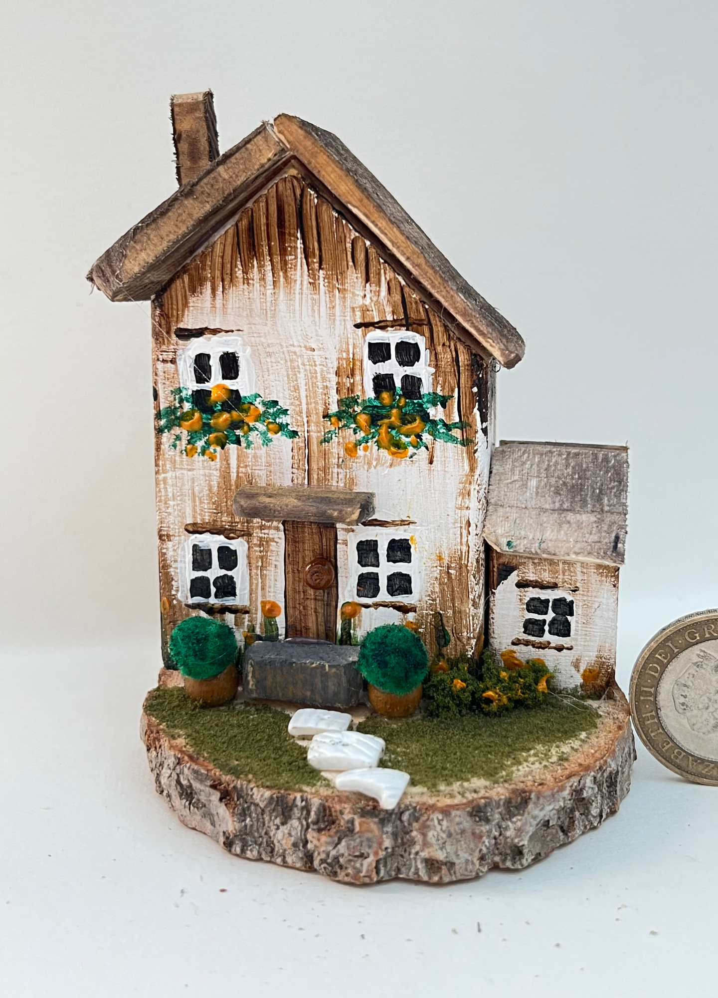 Miniature diorama with a house, and plants on a white background (RRH1045)