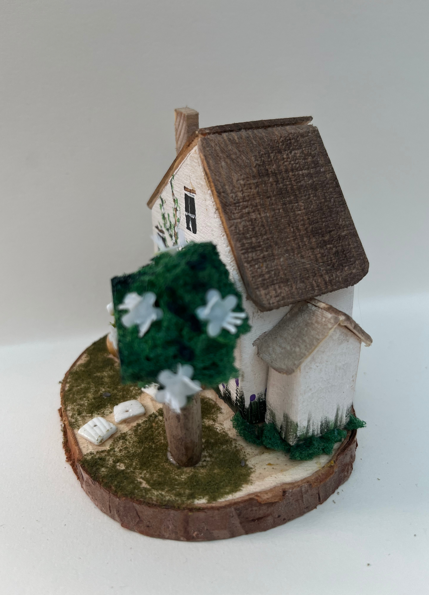 Miniature diorama with a house, and plants on a white background (RRH1041)